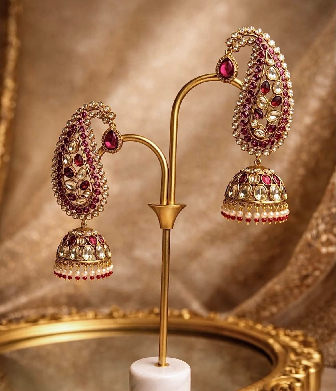 Ambi Jhumka — The paisley — the ambi — outlined in polki and filled with red, carrying a jhumka fringed in pearls and red beads.