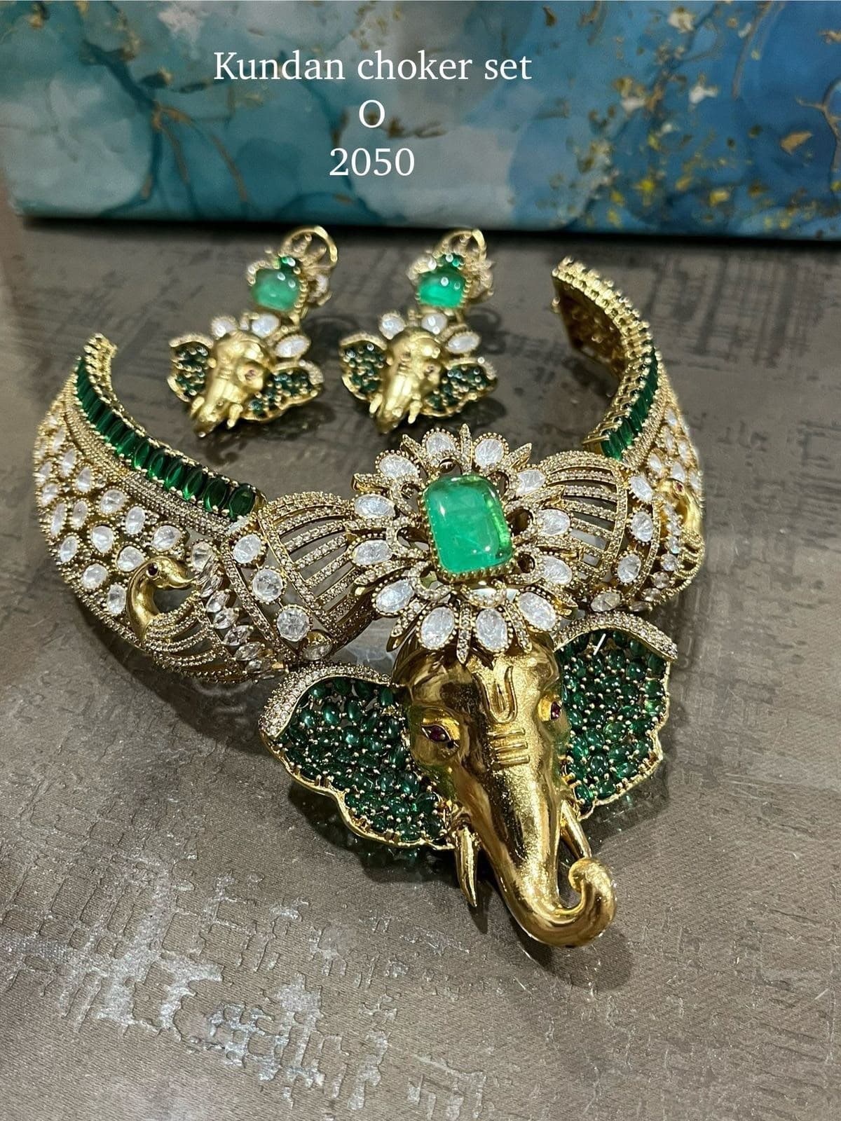 Gaja Emerald — A collar built around a single green cabochon, with an elephant at its heart and peacocks turned along the band.