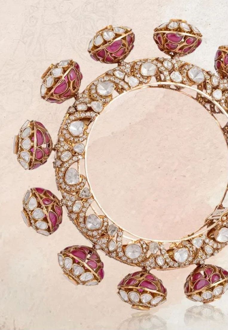 Gumbad — A band of polki and pavé ringed with small openwork domes, each caging red stones behind a lattice of gold.