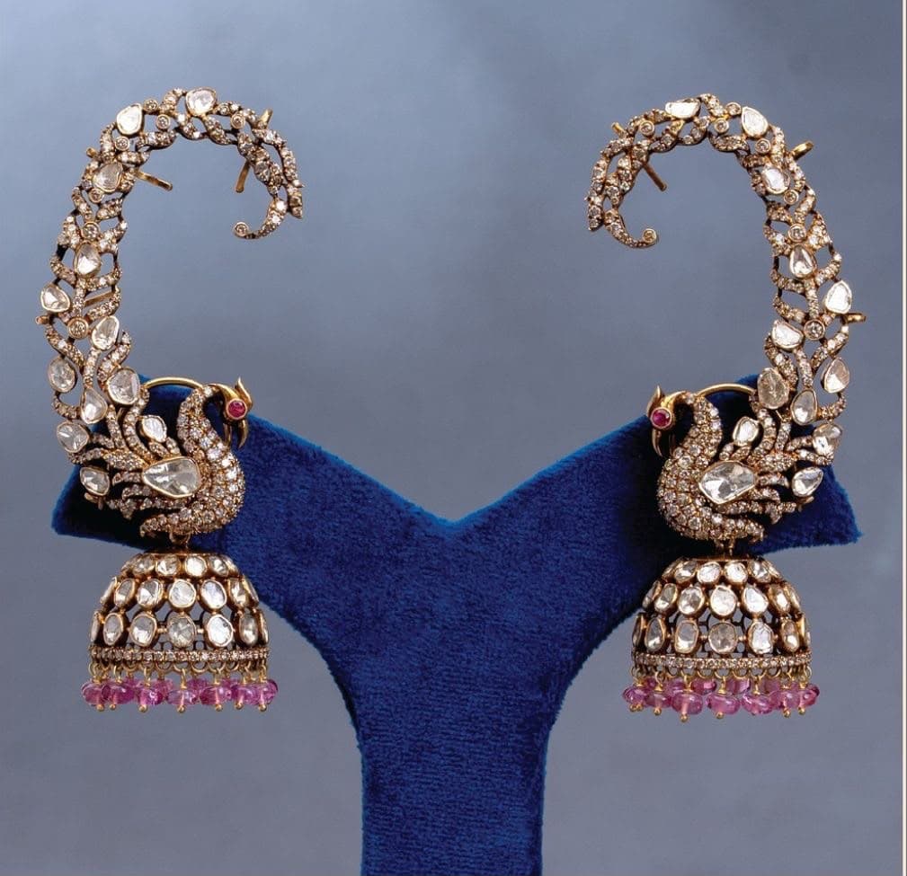 Peacock Ear Cuff — A stone-set sweep that follows the ear, a peacock at the turn, a jhumka and pink drops below.