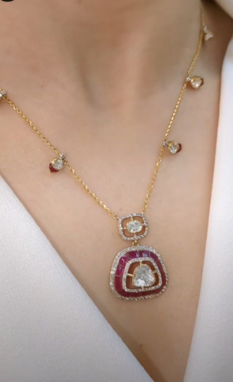Ruby Medallion — A red-bordered medallion on a chain scattered with small drops, made to sit close.